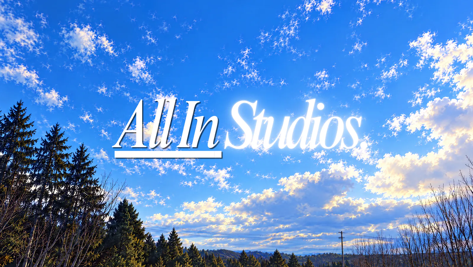 All In Studios: a cobalt sky with white clouds over a pine treeline